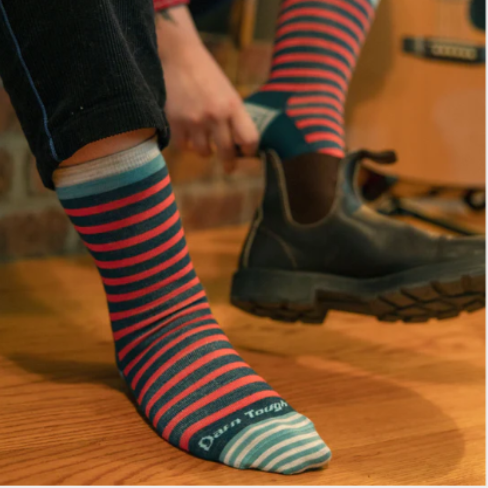 Darn Tough 6039 Morgan Lightweight Lifestyle Crew women's sock in teal featuring teal and pink stripes on a model putting on a boot