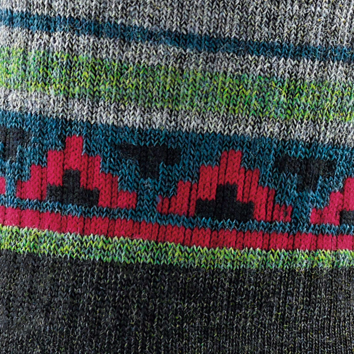 Detail of pattern on Darn Tough 1980 VanGrizzle Hiker Boot with Full Cushion Midweight Men&#39;s Crew Sock featuring charcoal sock with gray, green, red, and blue pattern around ankle with black bear. 