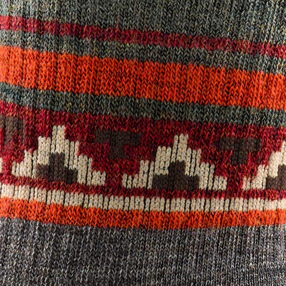 Detail of pattern on Darn Tough 1980 VanGrizzle Hiker Boot with Full Cushion Midweight Men&#39;s Crew Sock featuring taupe sock with red, orange, and brown pattern around ankle with brown bear.