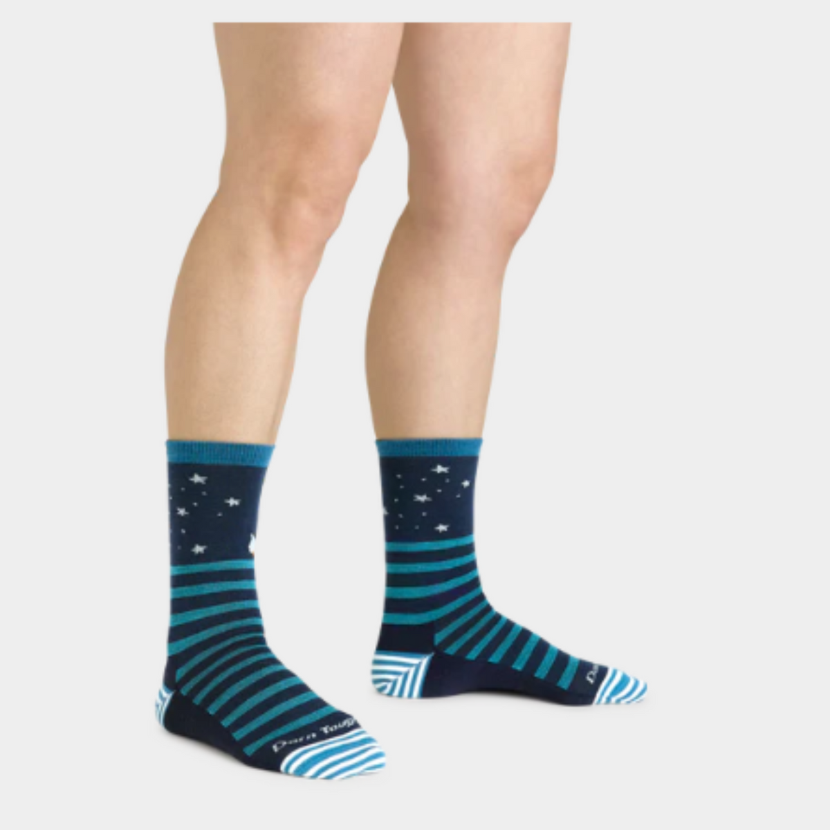 Darn Tough 6037 Animal Haus Lightweight Cushion Crew women&#39;s sock featuring navy blue sock with teal stripes and stars at top. Sock shown on model&#39;s feet.. 