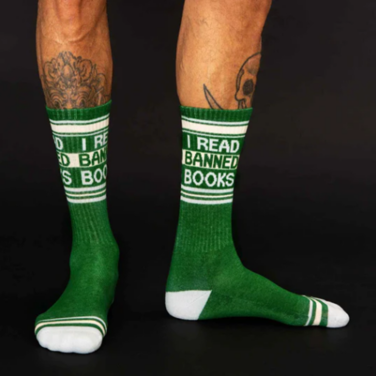 Gumball Poodle I Read Banned Books women&#39;s and men&#39;s crew sock featuring green sock with &quot;I Read Banned Books&quot; at top. Socks worn by model. 