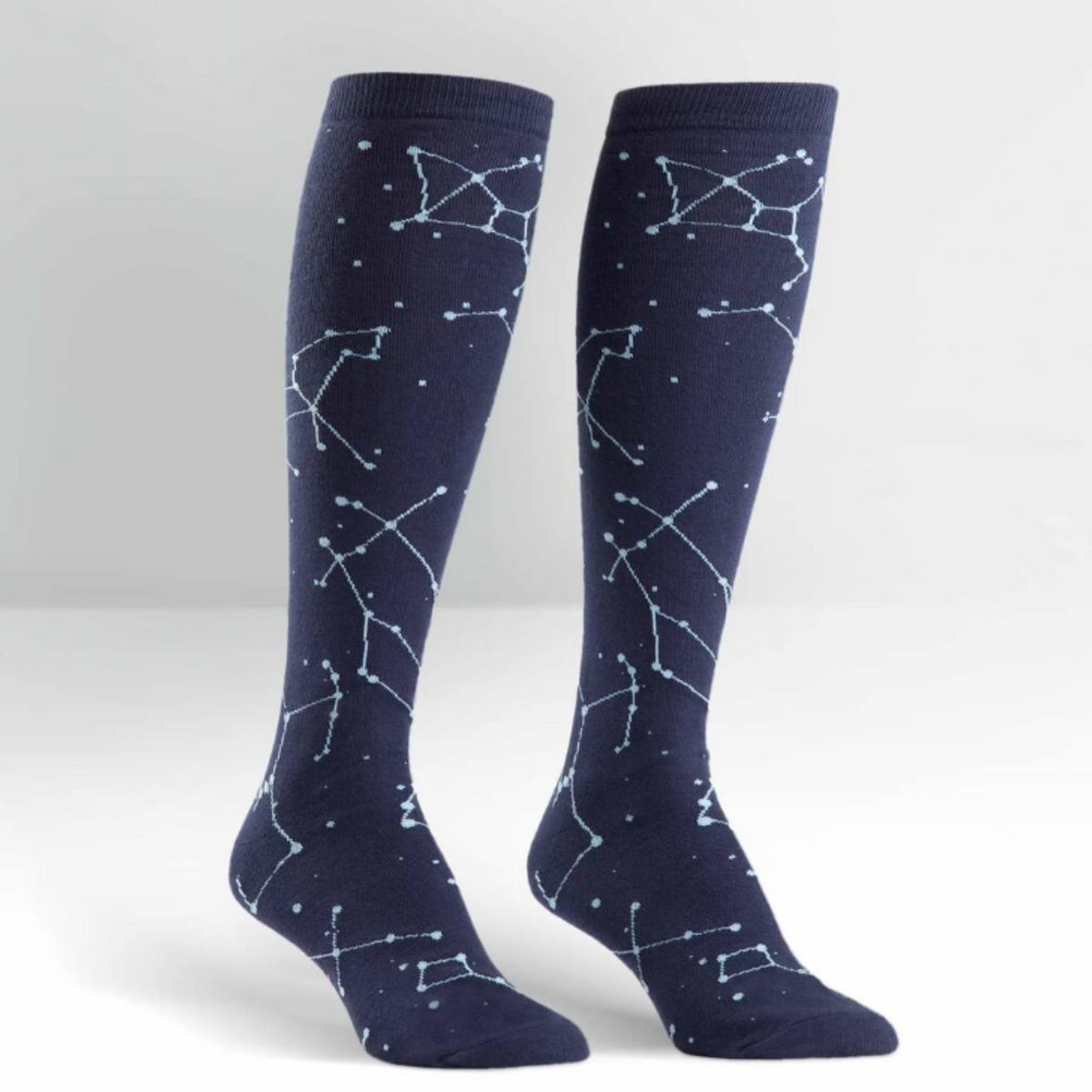 Sock It To Me Constellation (GLOWS IN THE DARK!) women&#39;s knee high sock. Featuring navy blue sock with constellations all over. Socks shown on display feet. 
