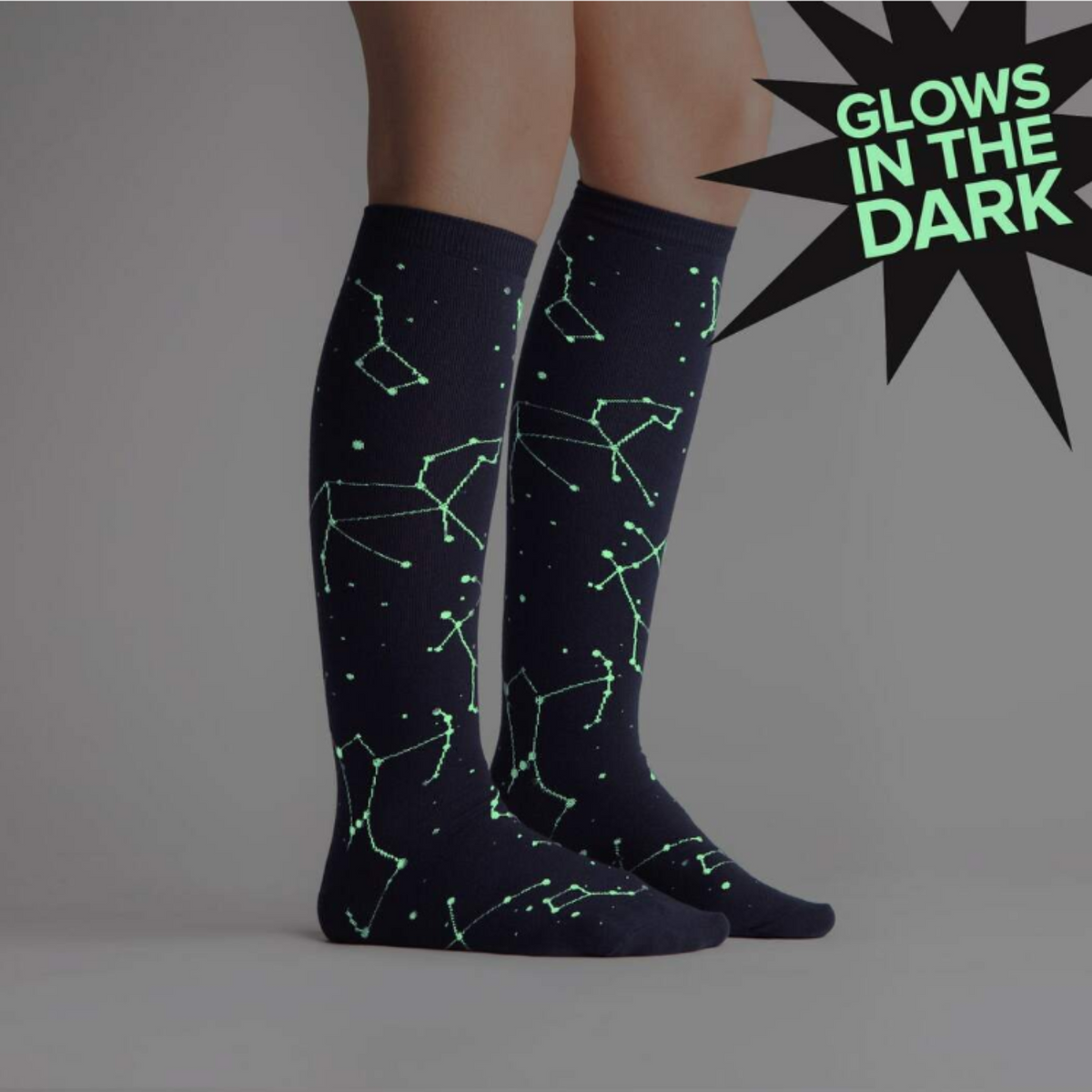Sock It To Me Constellation (GLOWS IN THE DARK!) women&#39;s knee high sock. Featuring navy blue sock with constellations all over. Socks worn by model, socks are glowing in the dark. 