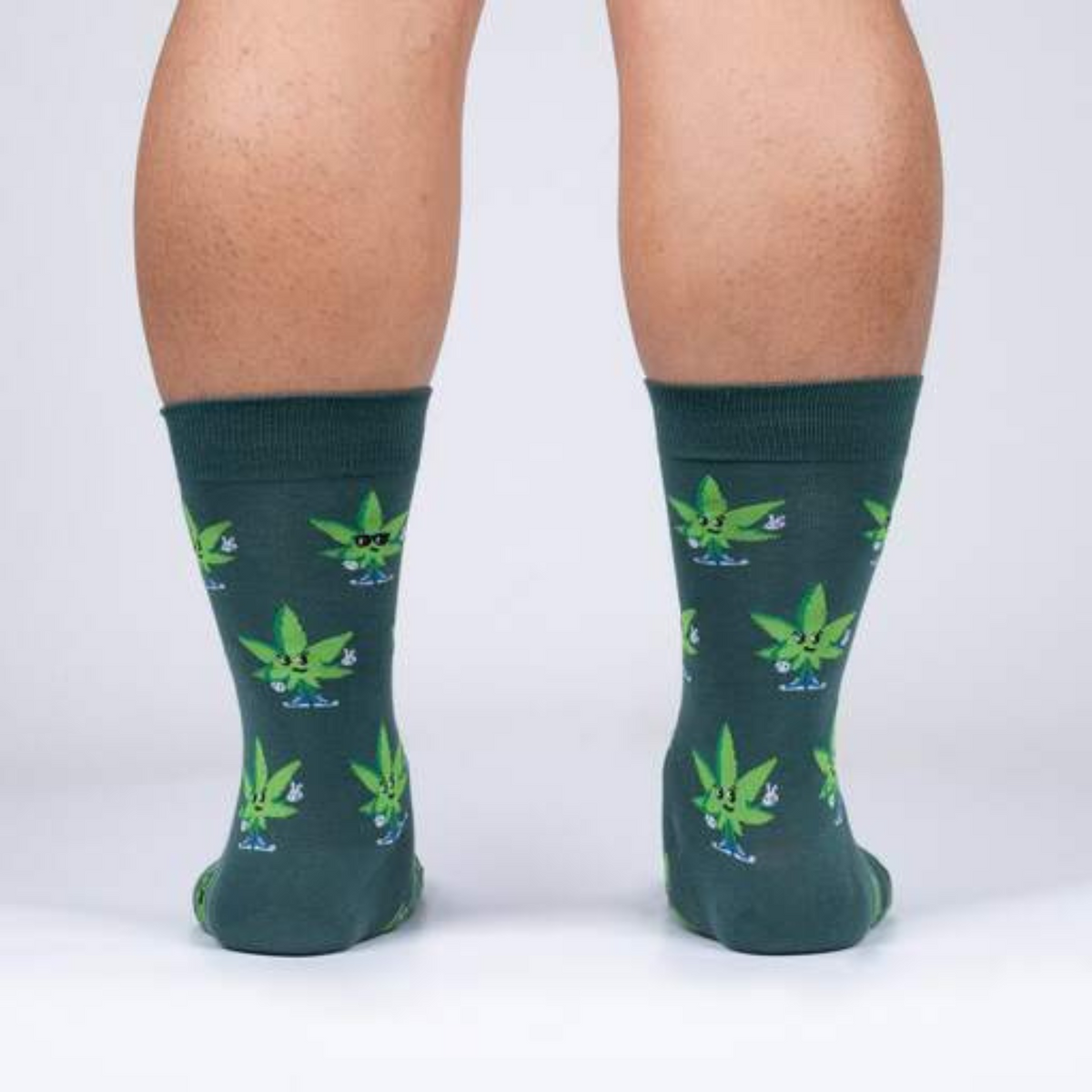 Sock It To Me Peace Out men&#39;s sock featuring green sock with cannabis leaves worn by model shown from back