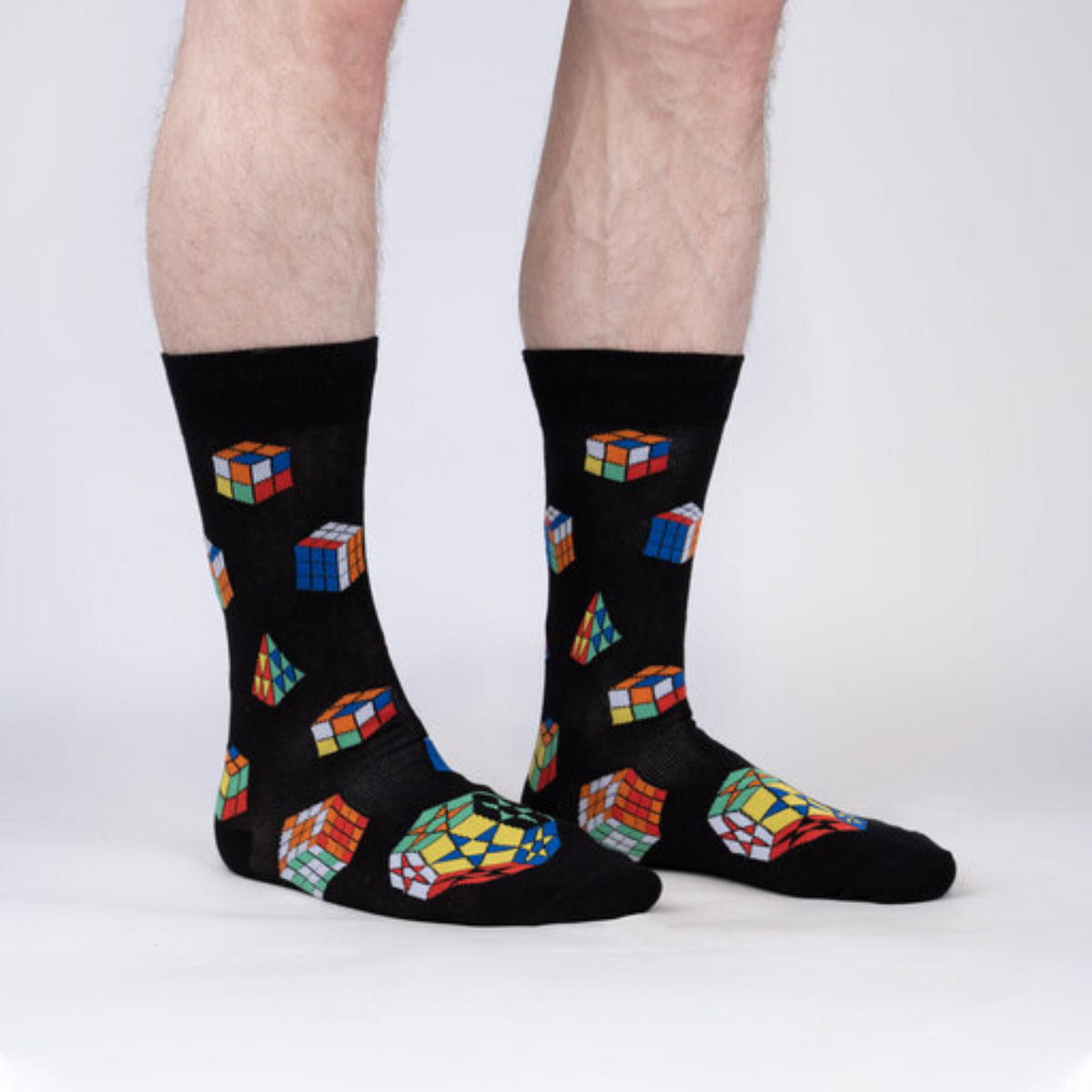 Sock It To Me Puzzle Box men&#39;s sock featuring black sock with cube color match puzzle game worn by model from side