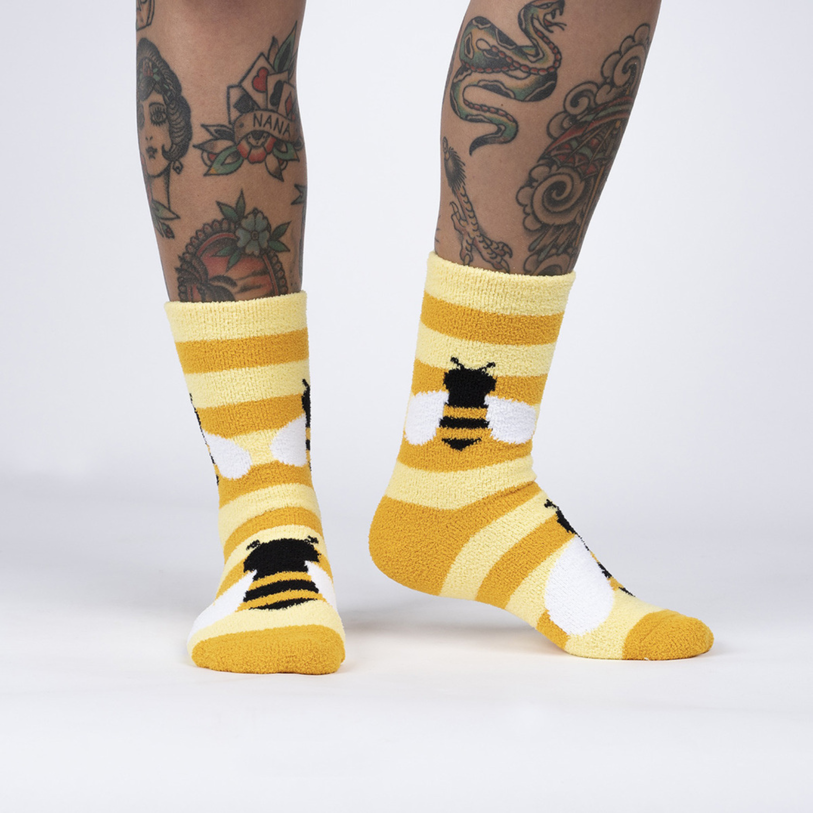 Sock It To Me Bee Cozy women's yellow stripe slipper sock featuring bees all over on model from side