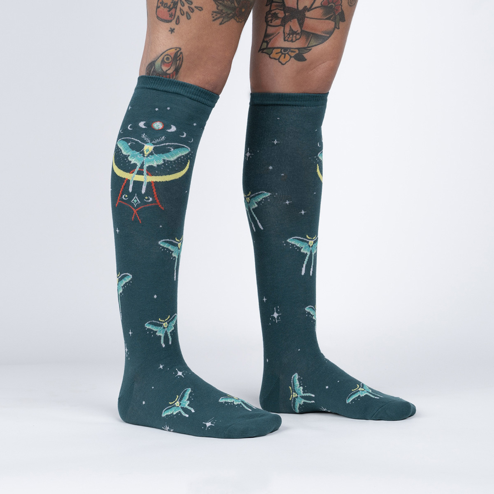 Sock It To Me Mystic Moth women's sock (GLOWS IN THE DARK!) featuring teal knee high with moths all over worn by model 