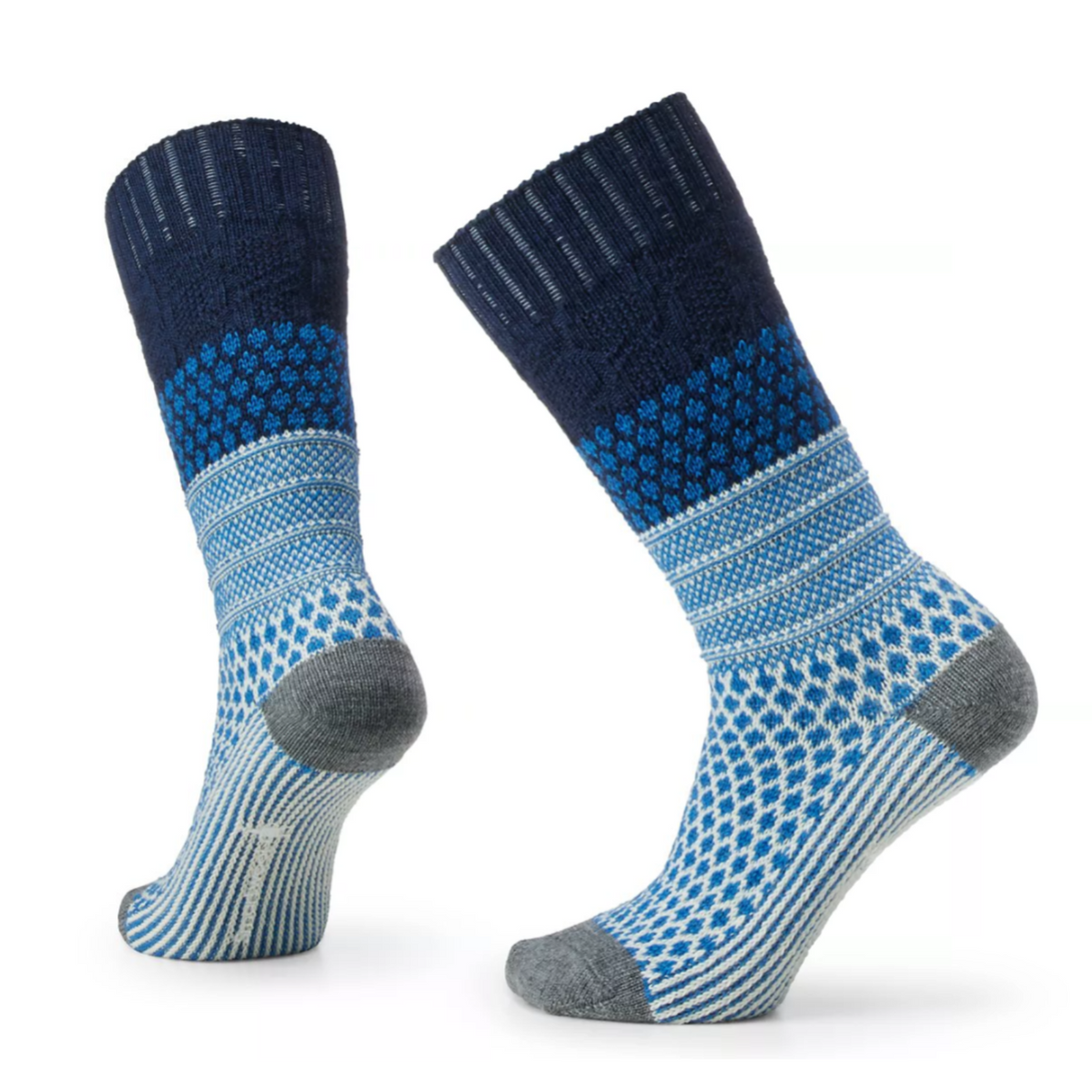 Smartwool Popcorn Cable Crew women&#39;s sock featuring navy blue colored cuff, and multiple shades of blue pattern on rest of sock, gray toe and heel. Socks on display feet. 