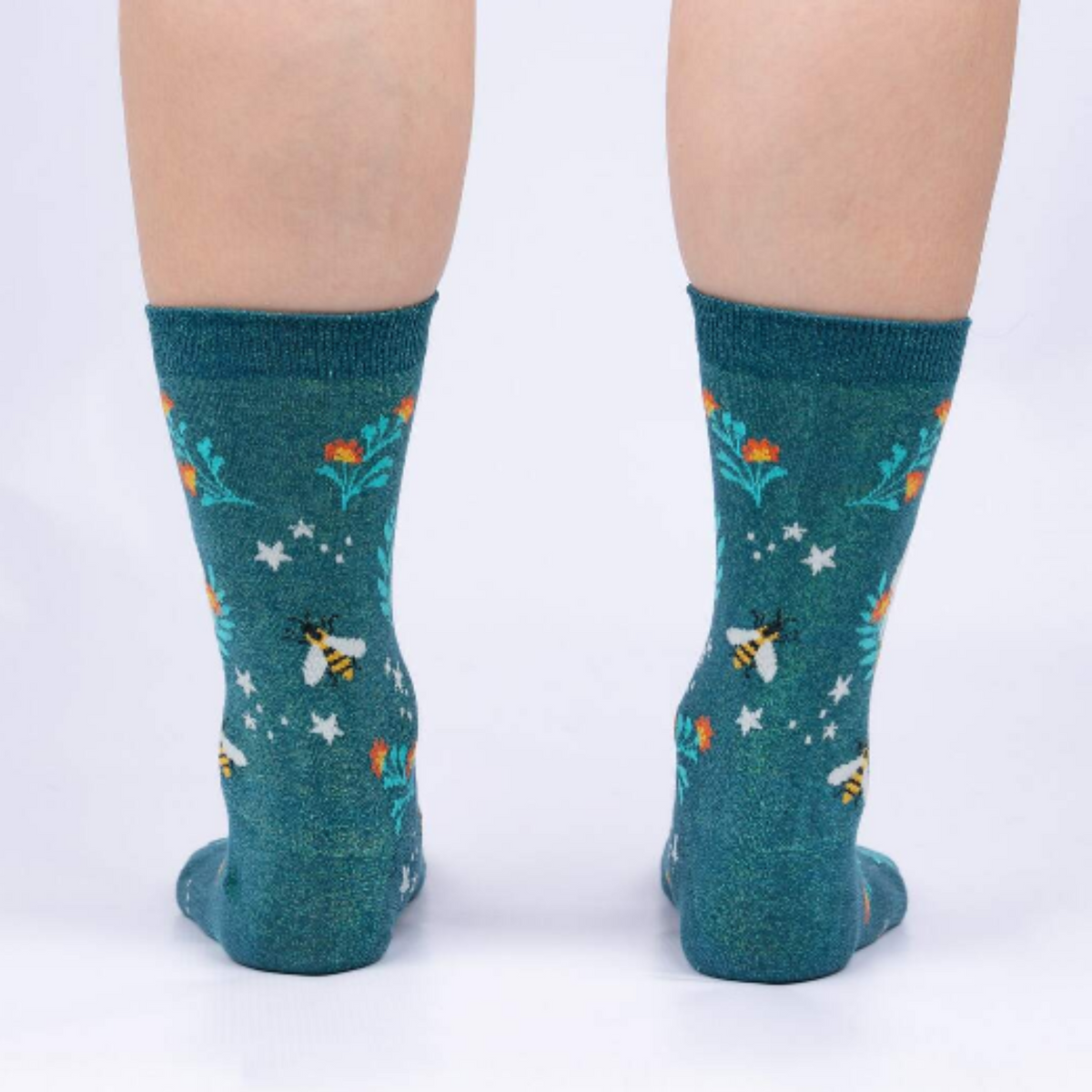 Sock It To Me Bee Dazzling women&#39;s crew sock featuring green shimmery socks with bees and flowers all over. Shown on model seen from back. . 