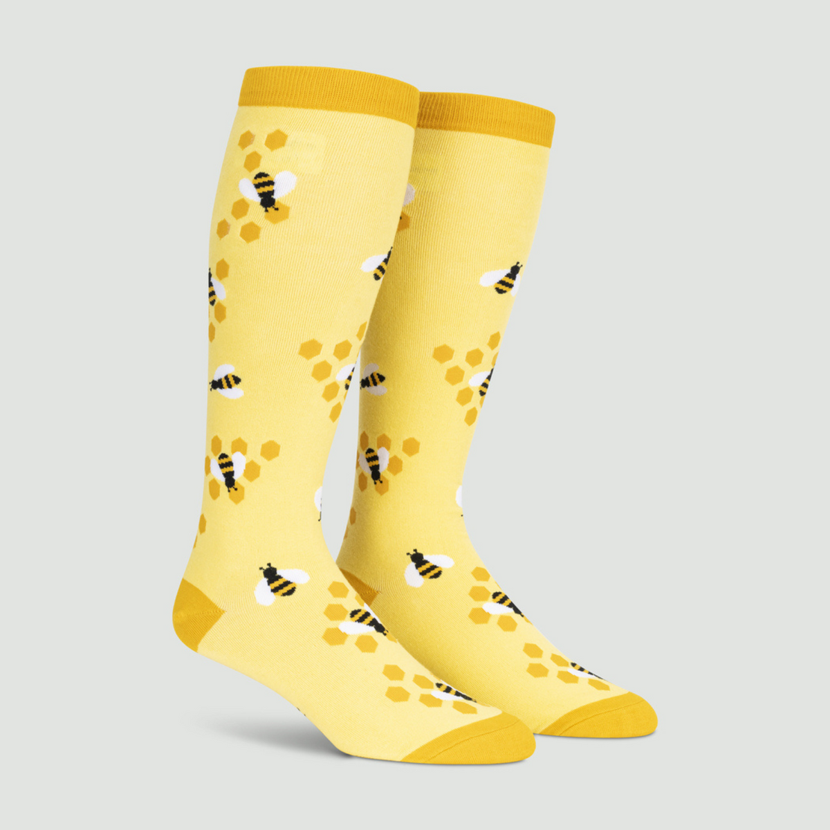 Sock It To Me extra-stretchy yellow knee high sock Bees Knees featuring honeycomb and bees all over on display