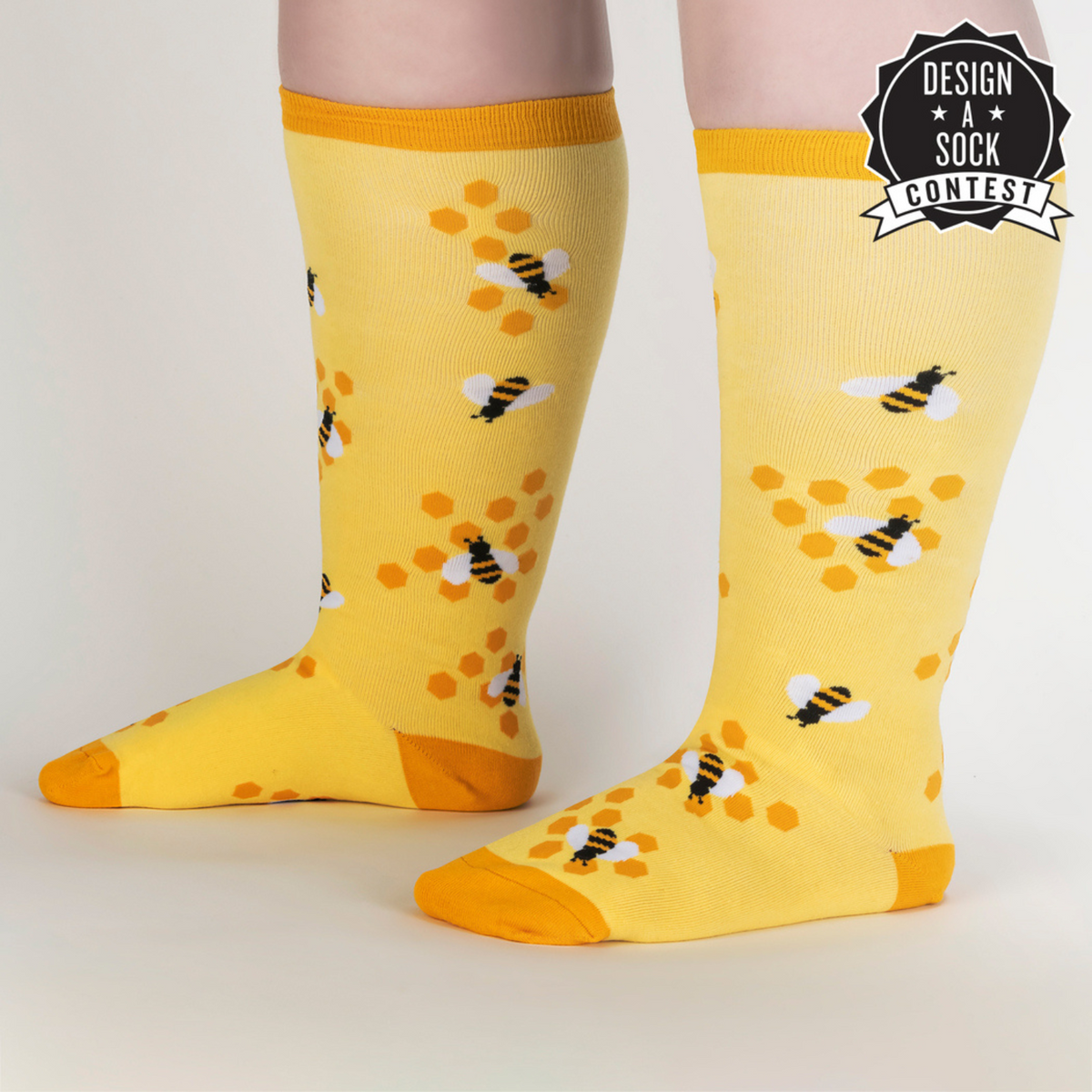 Sock It To Me extra-stretchy yellow knee high sock Bees Knees featuring honeycomb and bees all over on model from side