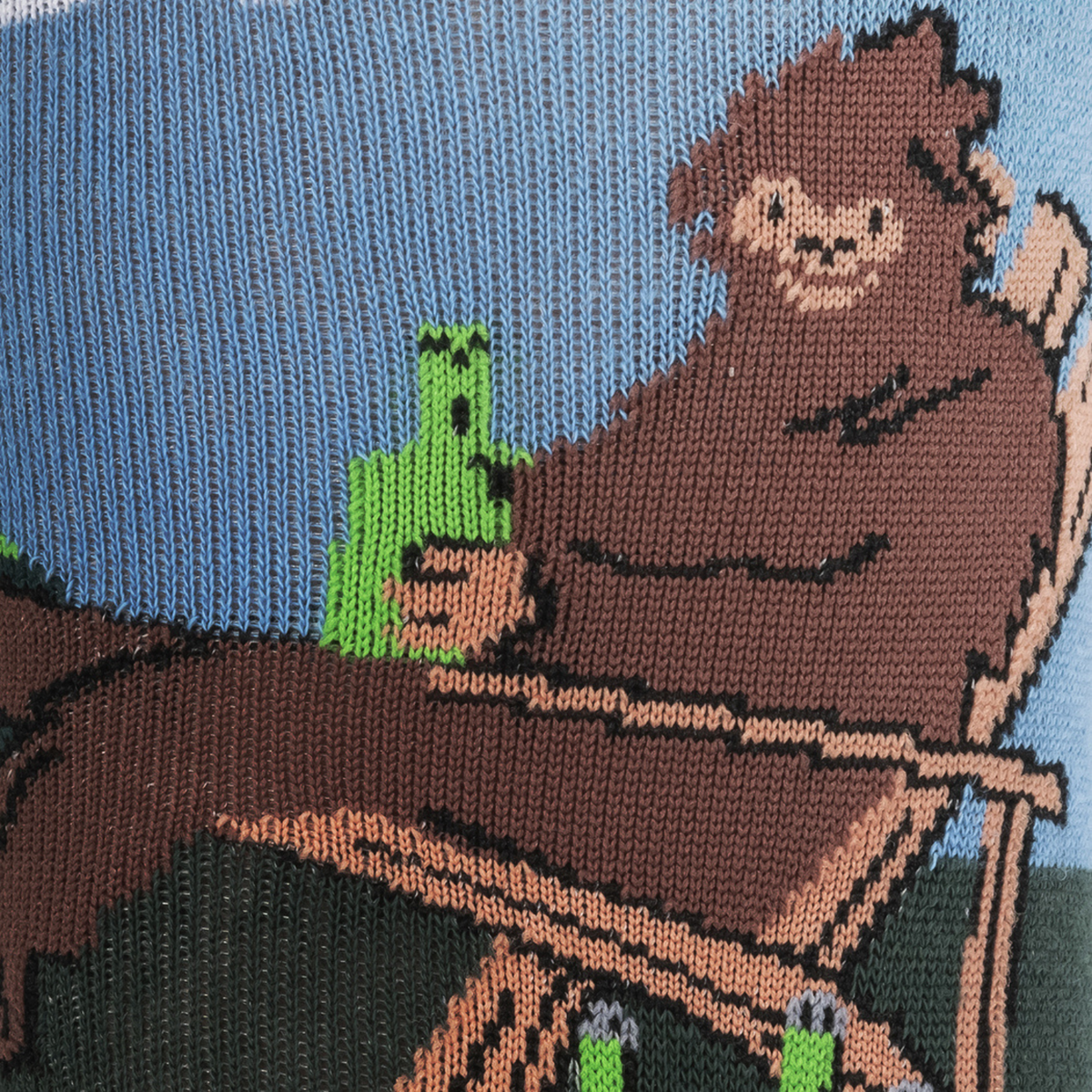Sock It To Me Bucket List men&#39;s crew sock featuring Sasquatch sitting on a lawn in a chair drinking beer with a bucket of beer detail of smiling Sasquatch