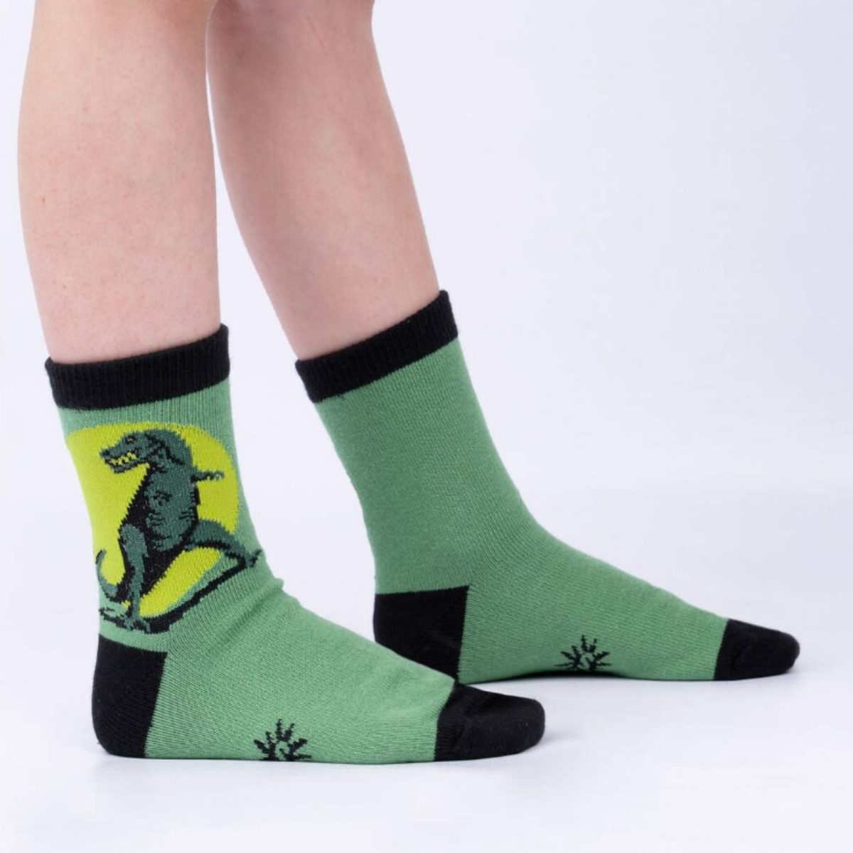 Sock It To Me Dinosaur Days 3-pack kids&#39; crew socks (GLOWS IN THE DARK!) featuring T-Rex style of dinosaur-themed socks on model seen from side