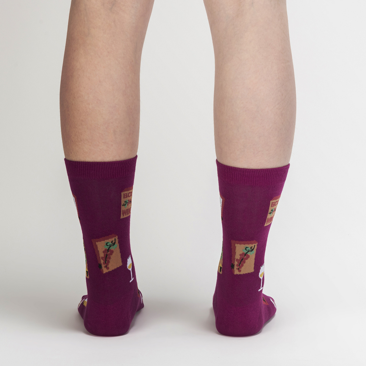 Sock It To Me It&#39;s Wine Time women&#39;s sock featuring purple sock with wine glasses and boxes of wine all over worn by model seen from back
