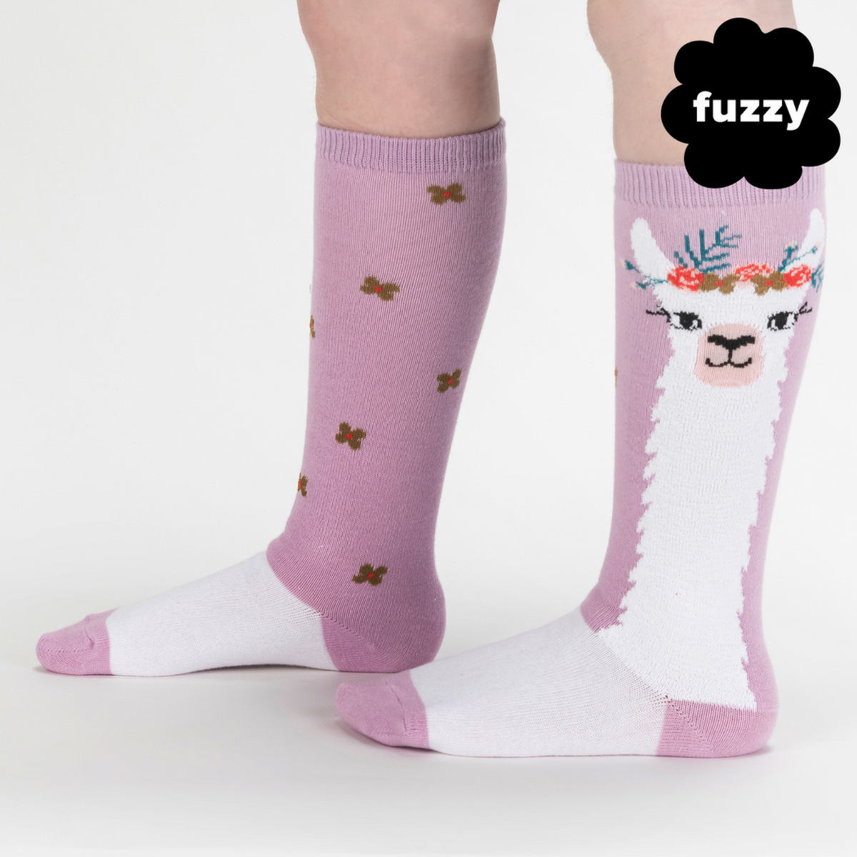 Sock It To Me Llama Queen kids&#39; sock featuring purple knee high sock with white llama wearing a floral crown worn by model seen from side