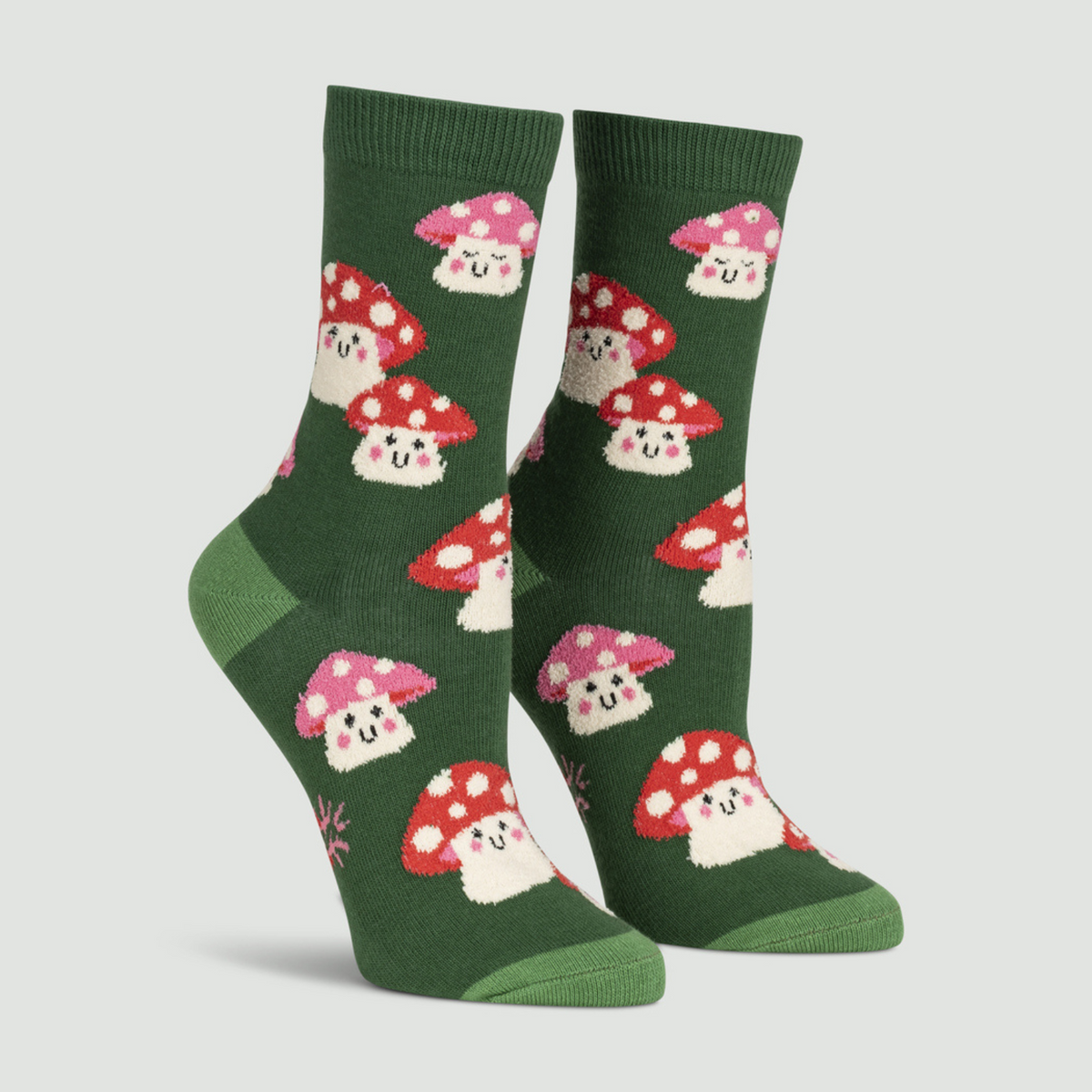Sock It To Me Mellow Mushrooms women&#39;s sock featuring a green crew sock with red capped smiling mushrooms all over worn on display feet