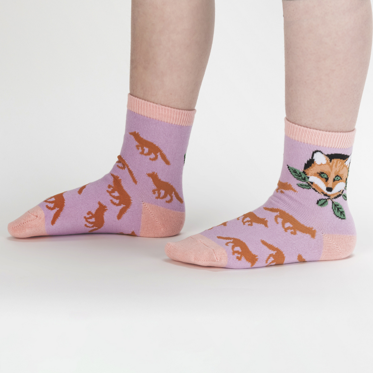 Sock It To Me My Dear Hedgehog 3-pack kids&#39; socks featuring lavender sock with orange foxes all over and fox face at ankle worn by model from side