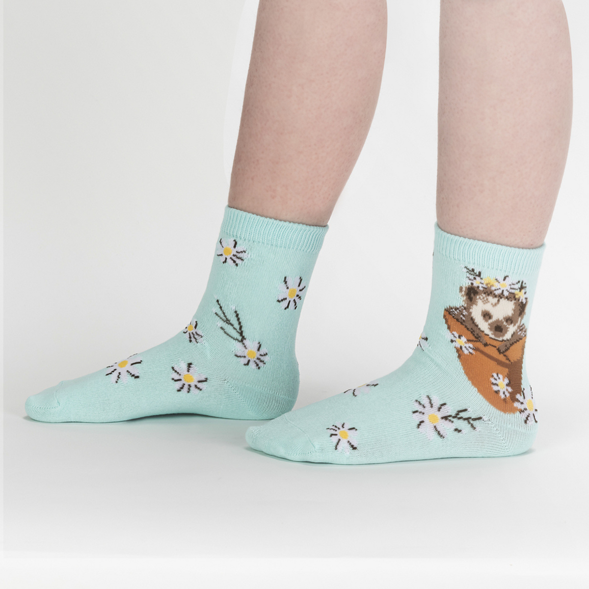 Sock It To Me My Dear Hedgehog 3-pack kids&#39; socks featuring pale blue sock with daisies all over and hedgehog at the ankle worn by model from side