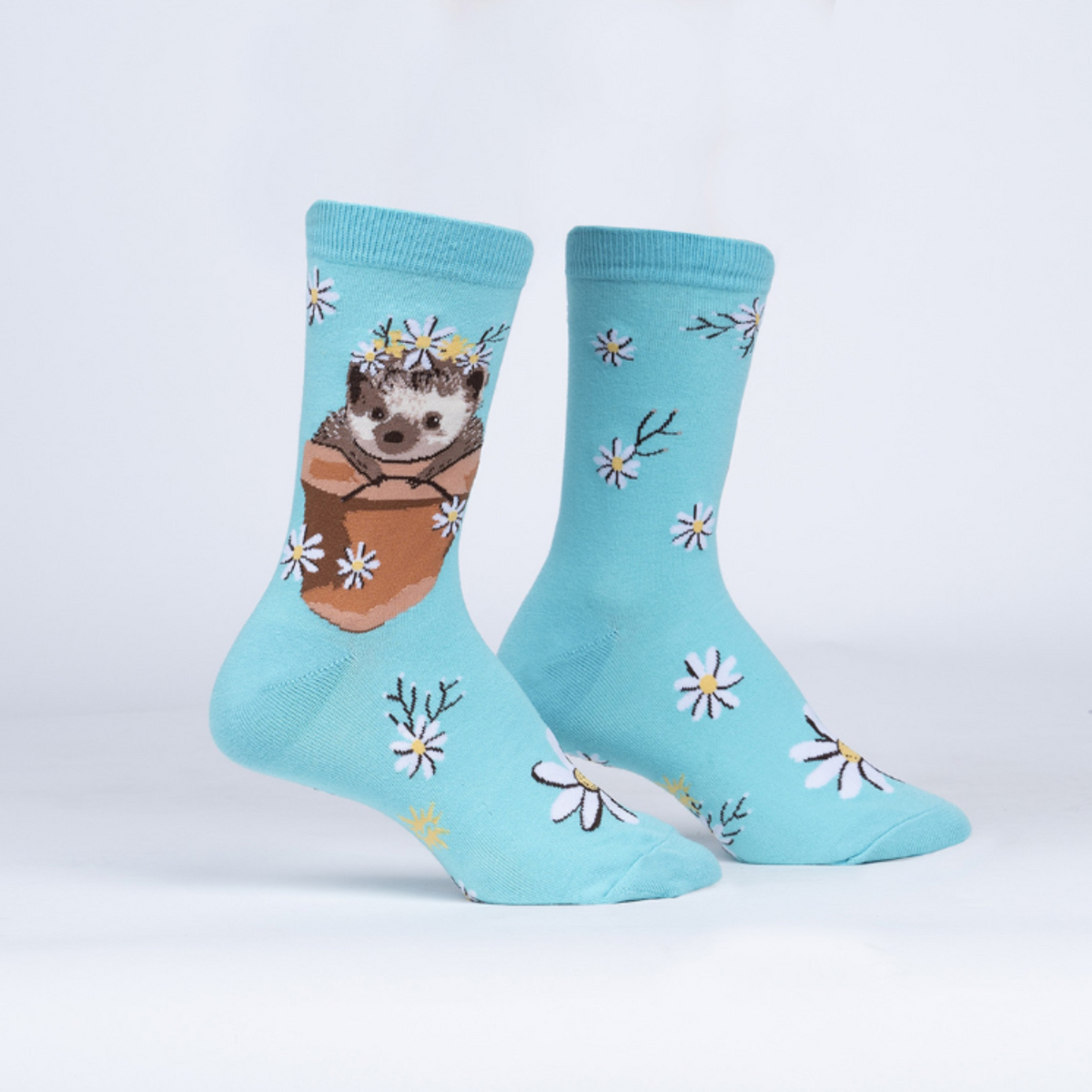 Sock It To Me My Dear Hedgehog women&#39;s crew sock featuring light blue sock with flowers all over and a hedgehog in a flower pot. Socks shown on display feet. 