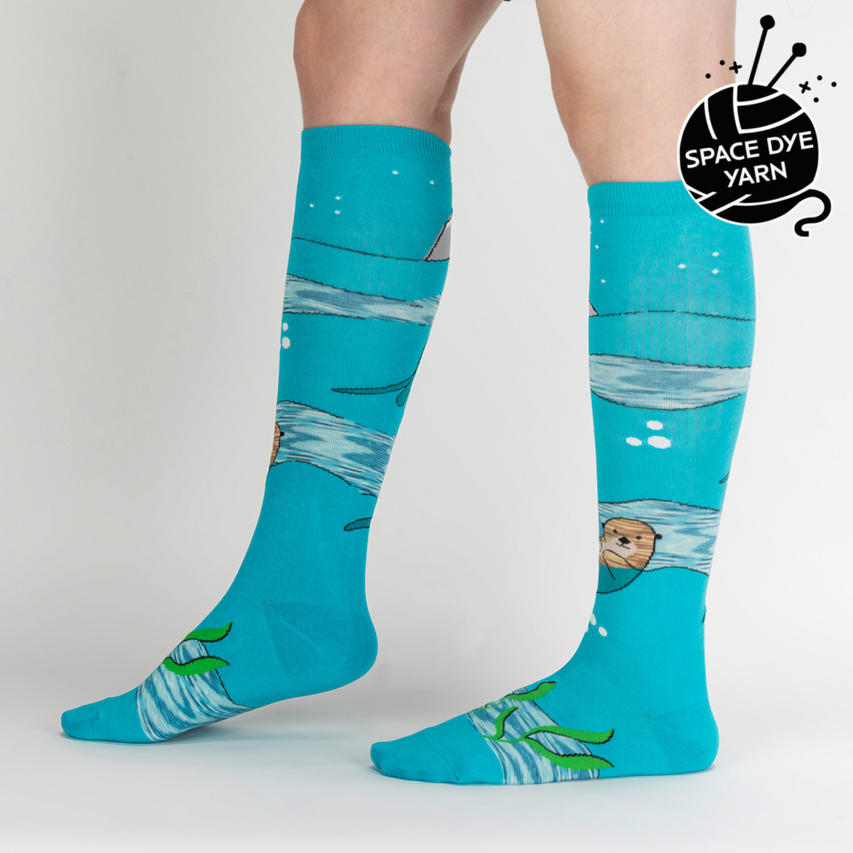 Sock It To Me Plays Well With Otters women&#39;s sock featuring blue knee high with otters and a puffin bird on model seen from side