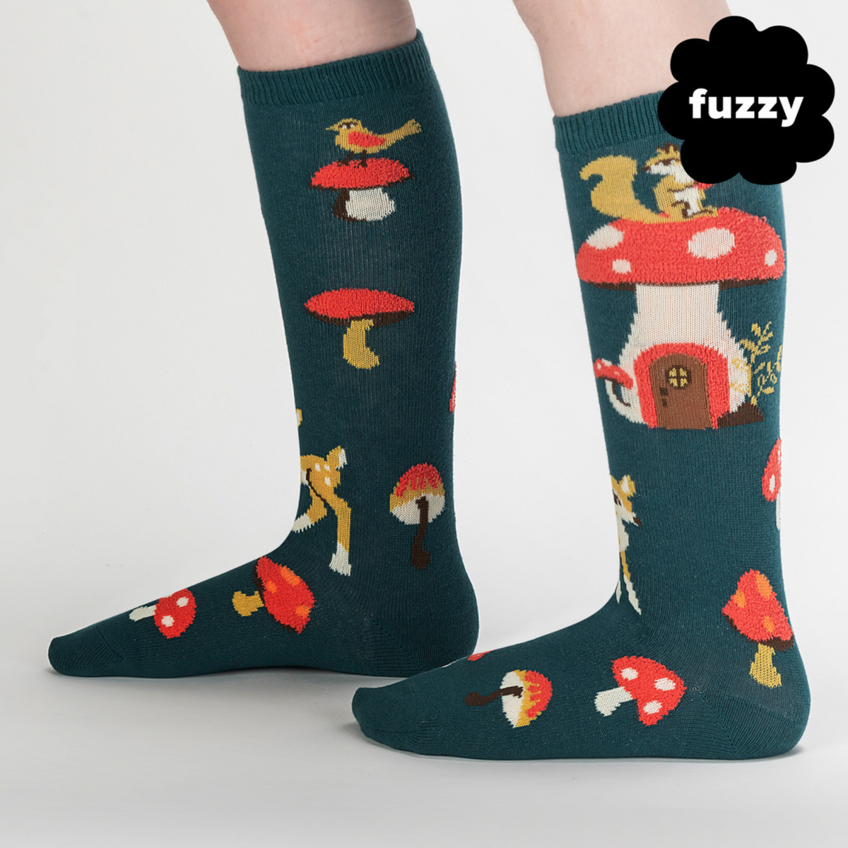 Kids&#39; Sock It To Me Shroom and Board women&#39;s and kids&#39; sock featuring green knee high with deer, squirrel, and mushrooms all over worn by model seen from side