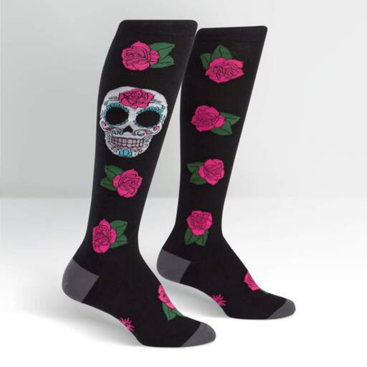 Sock It To Me Sugar Skull women&#39;s knee high sock featuring black sock with red roses all over and large Day of the Dead Sugar Skull. Socks shown on display feet. 