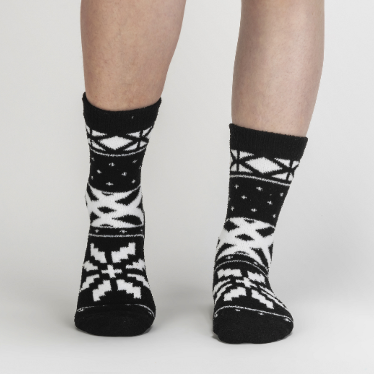 Sock It To Me You Sweater Believe It women&#39;s slipper sock featuring black fair isle pattern. Socks worn by model seen from front. 