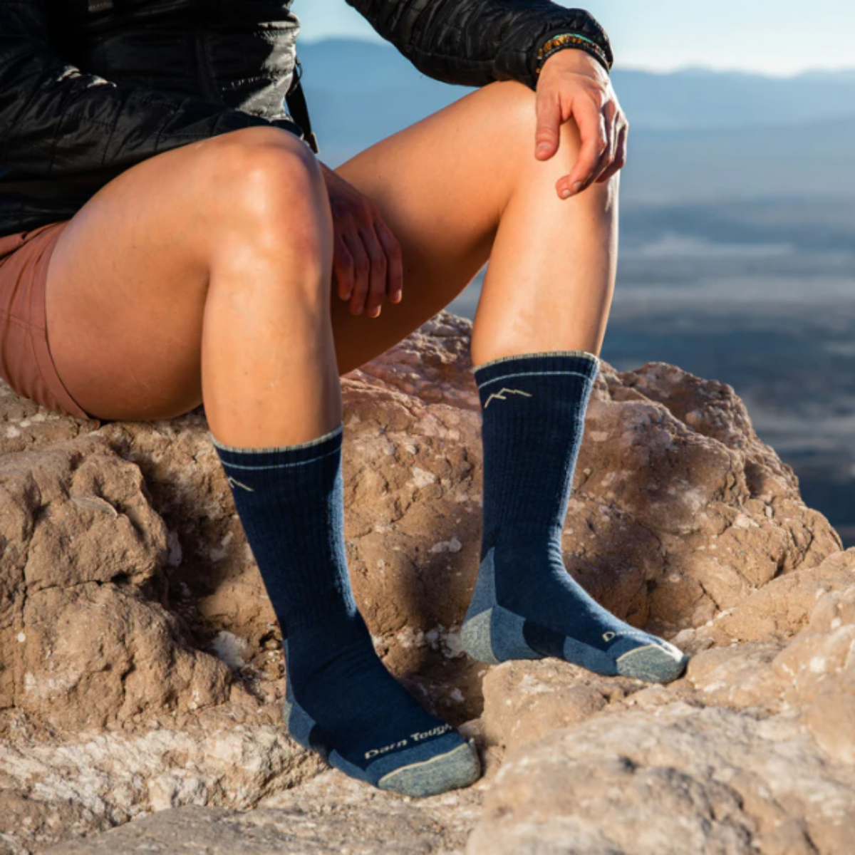Darn Tough 1907 Hiker Boot Midweight with Cushion Women&#39;s Sock in blue Eclipse on model on a rock