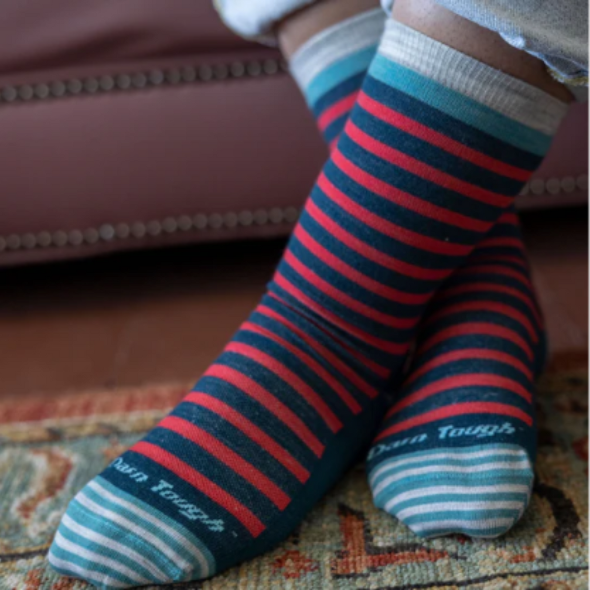Darn Tough 6039 Morgan Lightweight Lifestyle Crew women&#39;s sock in teal featuring teal and pink stripes on a model with feet crossed at ankles