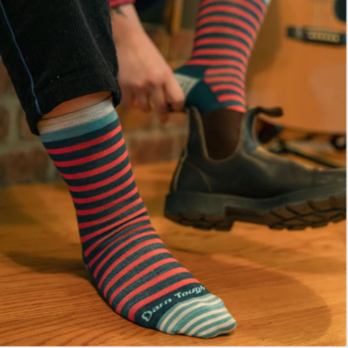 Darn Tough 6039 Morgan Lightweight Lifestyle Crew women&#39;s sock in teal featuring teal and pink stripes on a model putting on a boot