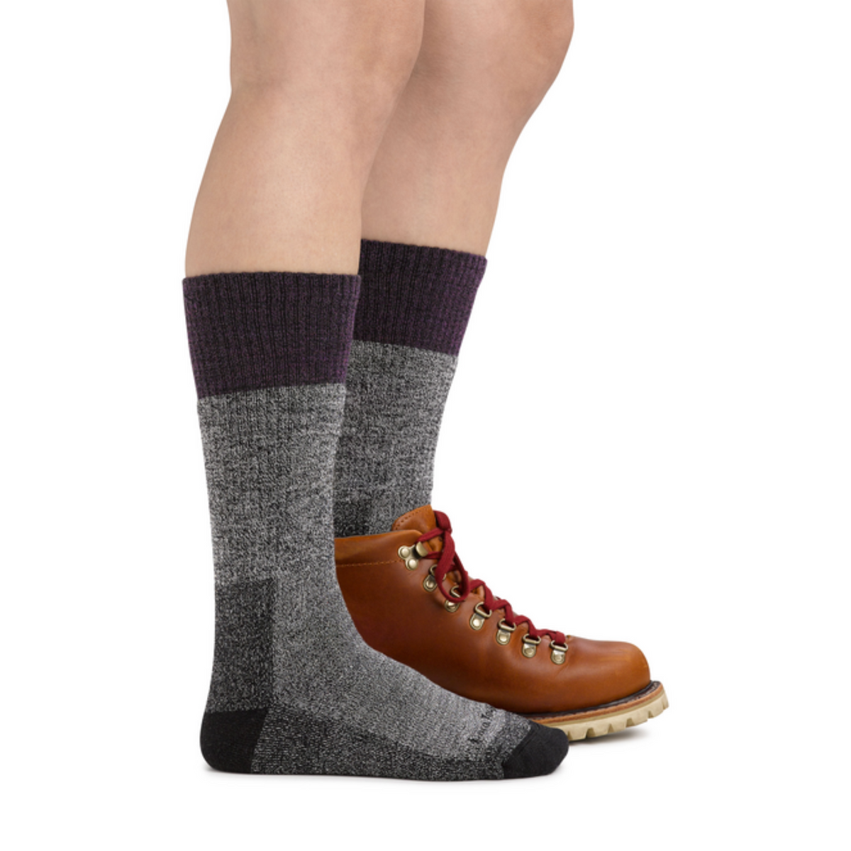 Darn Tough 1983 Scout Midweight Hiking Boot women&#39;s sock featuring grey sock with purple cuff worn by model wearing one hiking boot to show the size