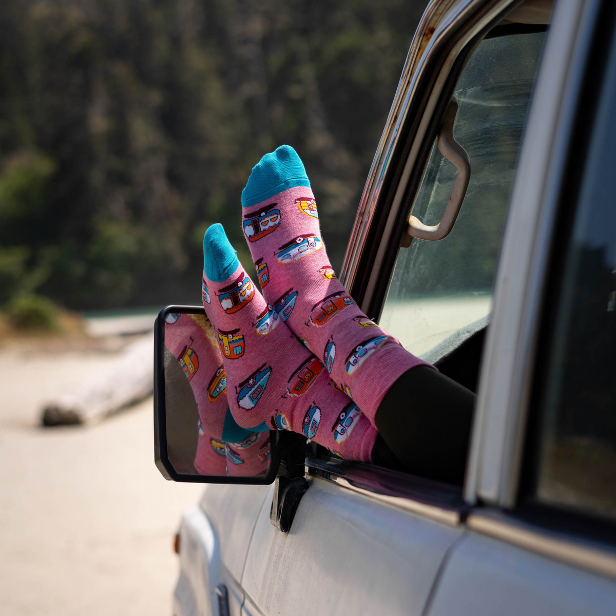 Good Luck Sock Happy Camper women&#39;s sock featuring pink sock with RV and trailers on model&#39;s feet out car window