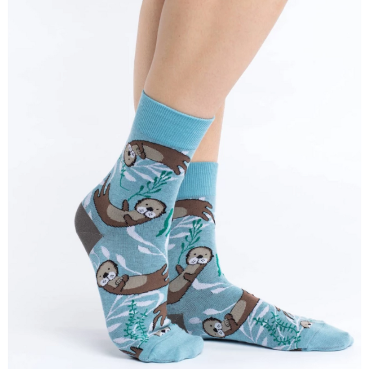 Good Luck Sock Sea Otter women&#39;s sock featuring blue sock with otters swimming with kelp on model