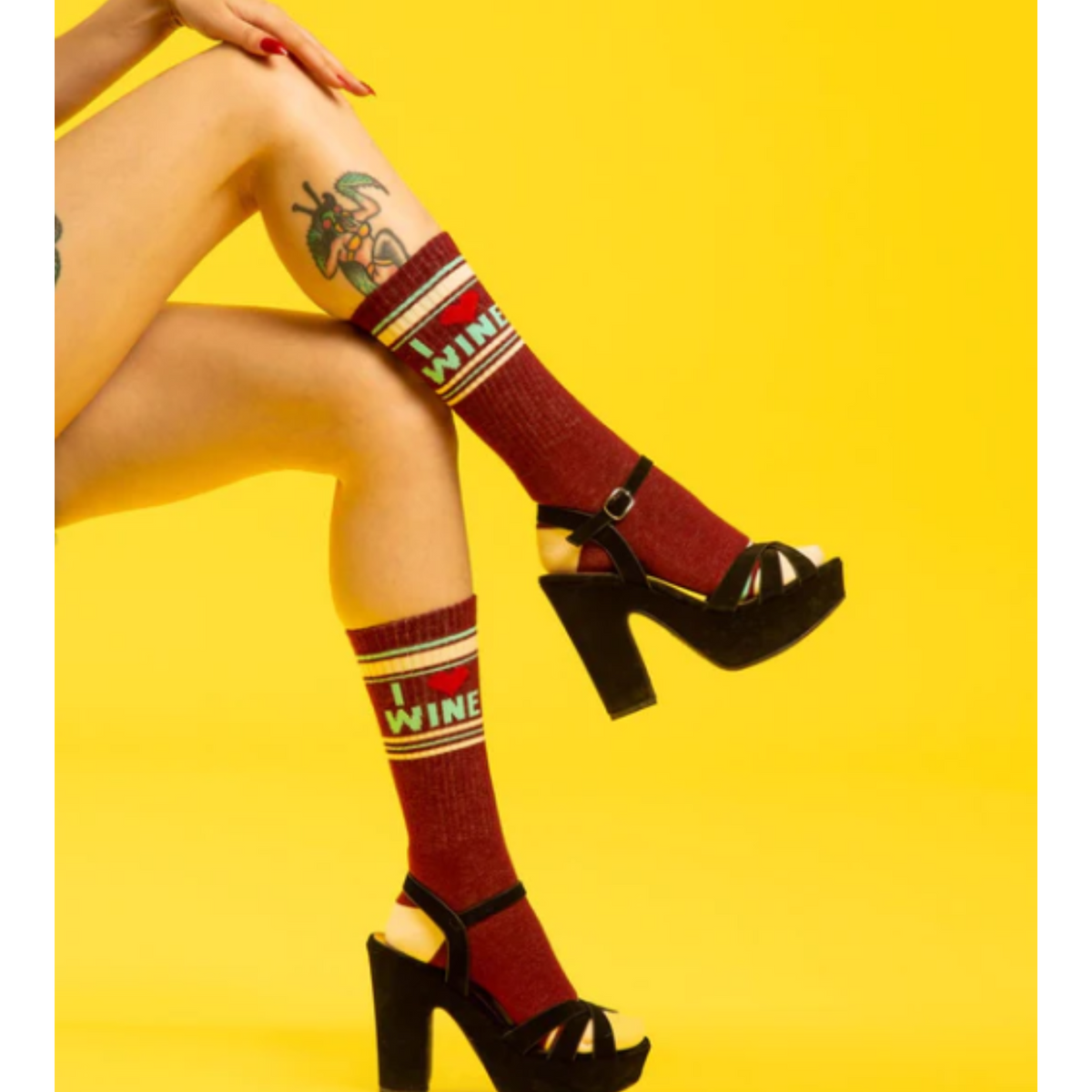 Model legs wearing Gumball Poodle I Love Wine women&#39;s and men&#39;s sock featuring burgundy sock with I (heart symbol) Wine 