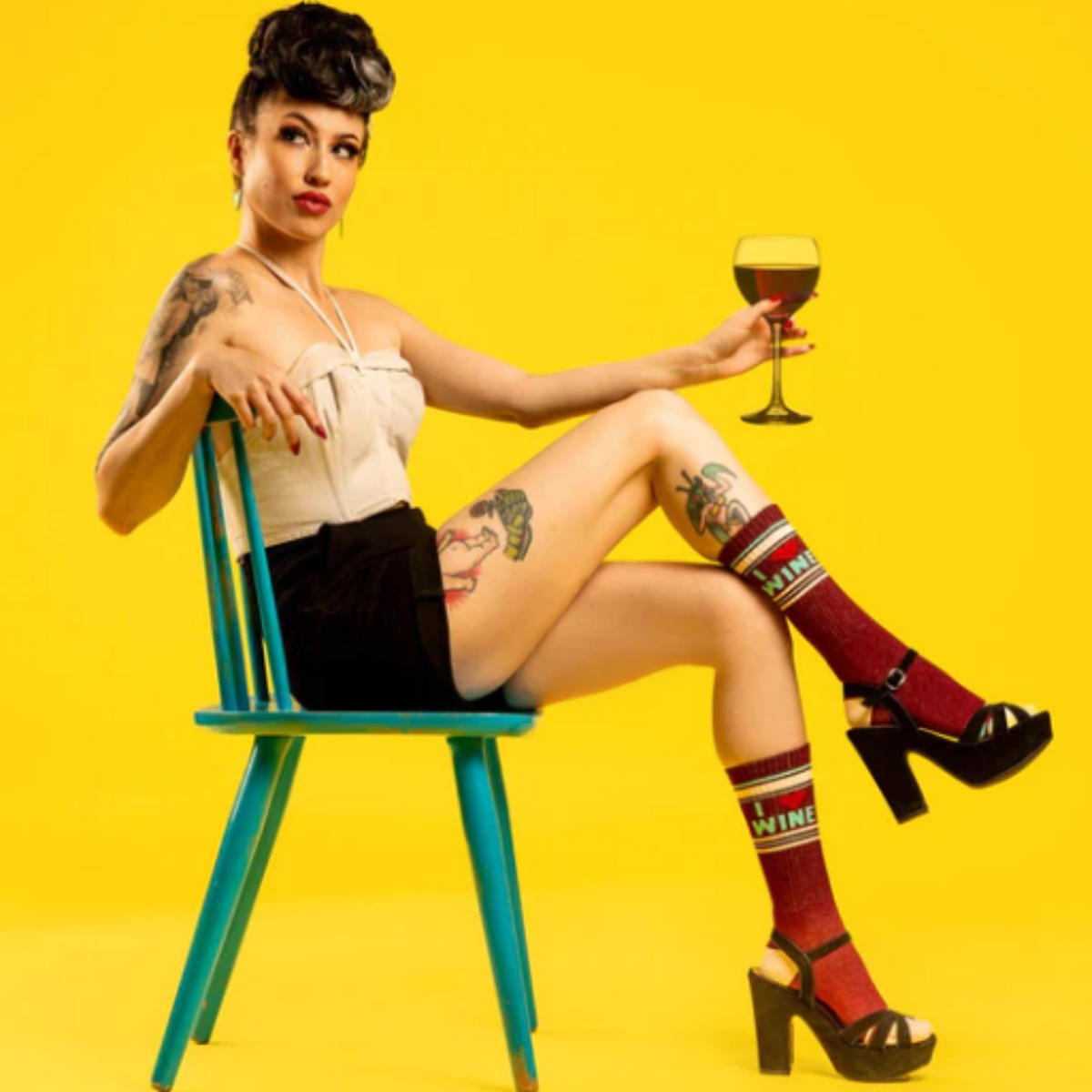 Model holding glass of wine wearing Gumball Poodle I Love Wine women&#39;s and men&#39;s sock featuring burgundy sock with I (heart symbol) Wine 