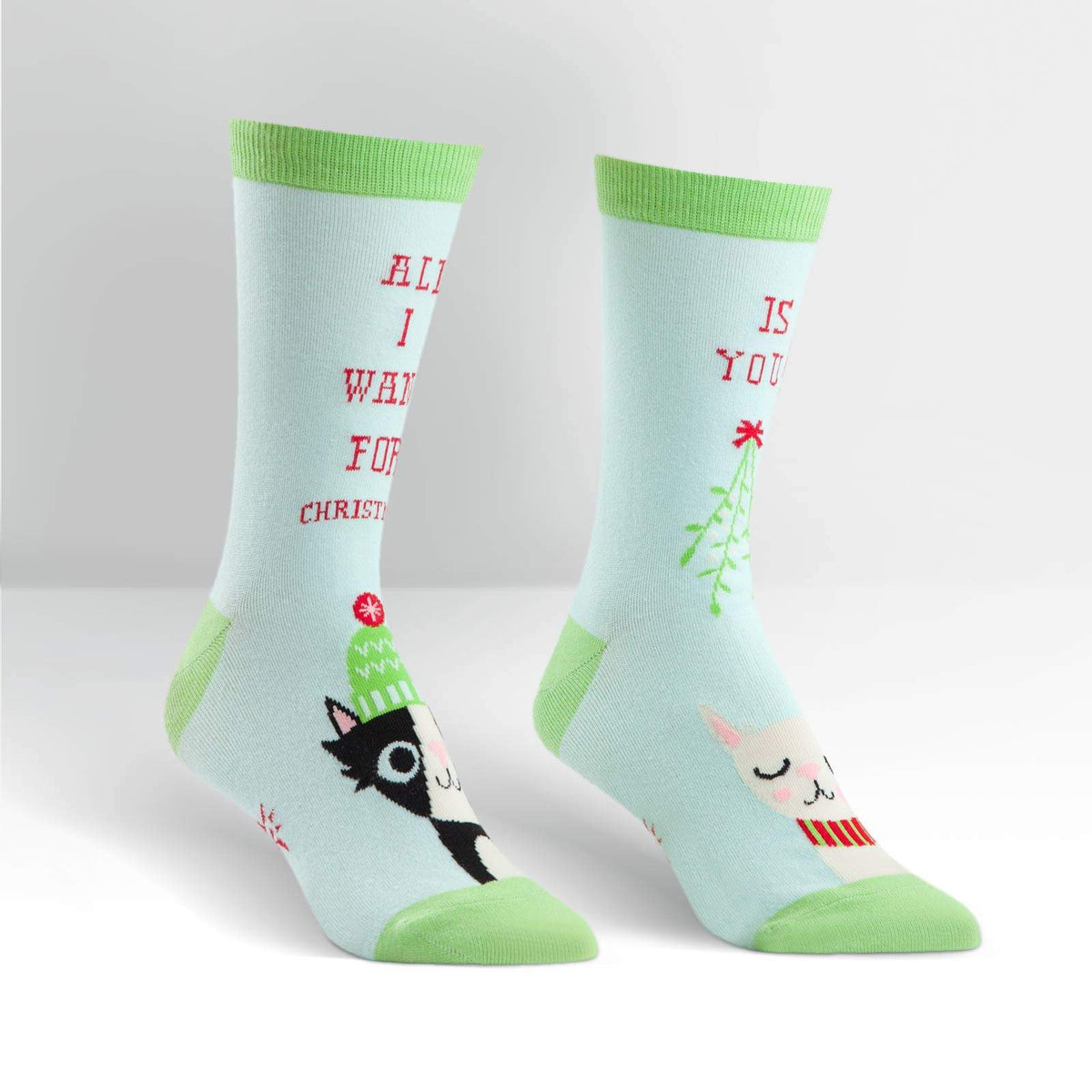 Sock It To Me All I Want for X-mas women&#39;s crew sock featuring light blue socks with cats and &quot;All I want for Christmas is You&quot;. Socks shown on display feet seen from side. 