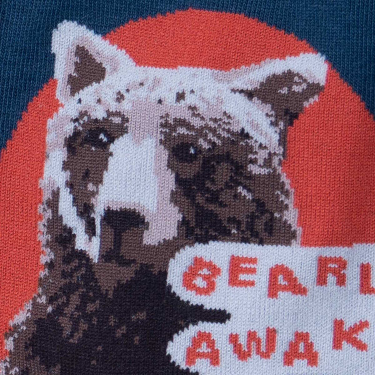 Detail of bear on Sock It To Me Bearly Awake women&#39;s and men&#39;s crew sock featuring blue sock with small red polka dots and picture of bear holding a cup of coffee and the saying &quot;bearly awake&quot;.