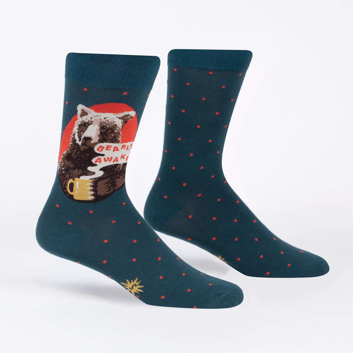 Sock It To Me Bearly Awake women&#39;s and men&#39;s crew sock featuring blue sock with small red polka dots and picture of bear holding a cup of coffee and the saying &quot;bearly awake&quot;. Socks shown on display feet. 
