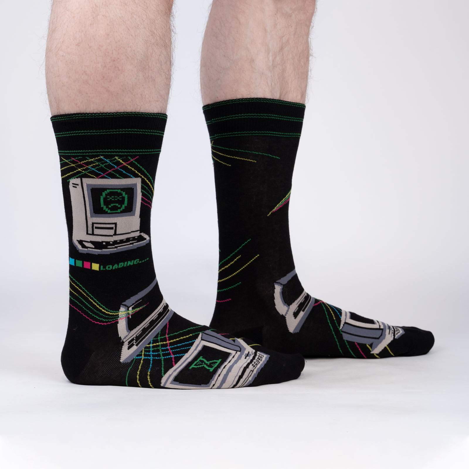 Sock It To Me Control Alt Delete men's crew sock featuring black sock with image of 1990s Mac computer with sad face. Socks worn by model seen from side. 