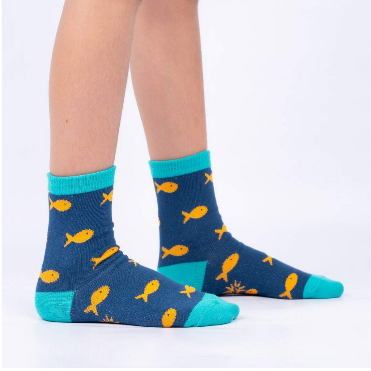 Sock It To Me My Otter Half 3-pack kids&#39; socks featuring navy blue socks with goldfish all over worn by model seen from the side