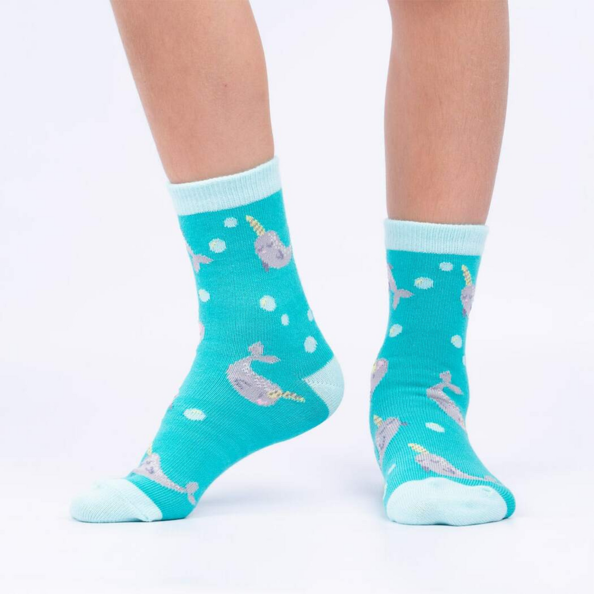 Sock It To Me My Otter Half 3-pack kids&#39; socks featuring light blue socks with narwhals all over worn by model seen from the side