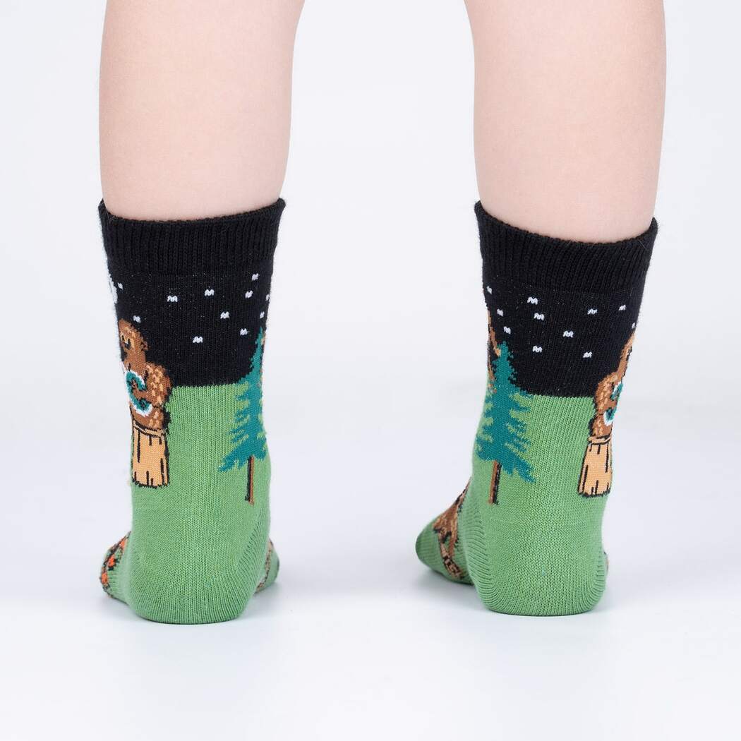 Sock It To Me Sasquatch Camp Out 3-pack kids&#39; crew socks featuring Sasquatch camping and playing the banjo socks on model seen from behind