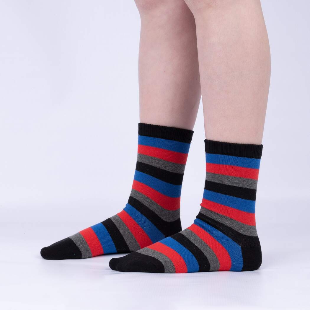 Sock It To Me Solar System (GLOWS IN THE DARK!) 3-pack kids&#39; socks featuring black, blue, red, and gray striped socks worn by model seen from the side