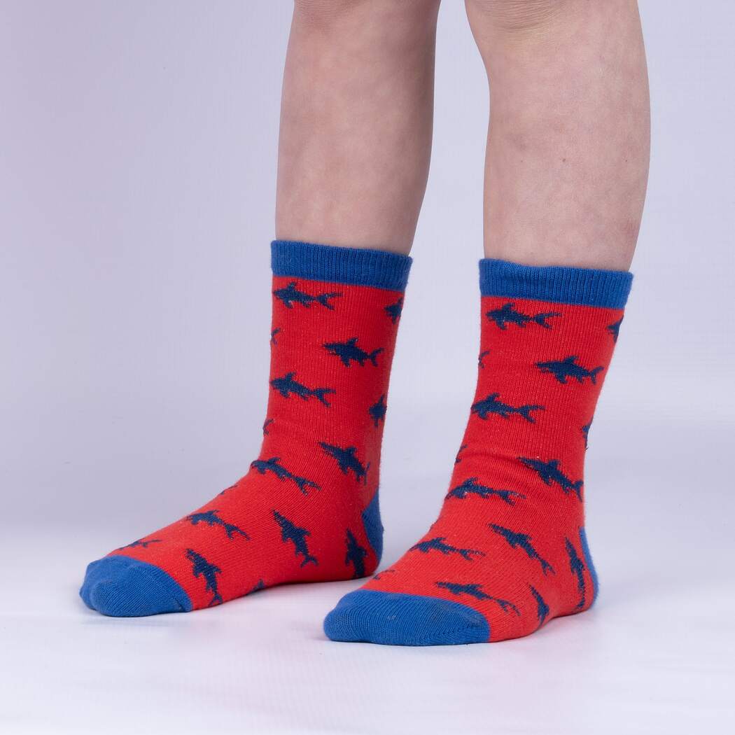 Child pair of red Sock It To Me socks with blue shark pattern all over