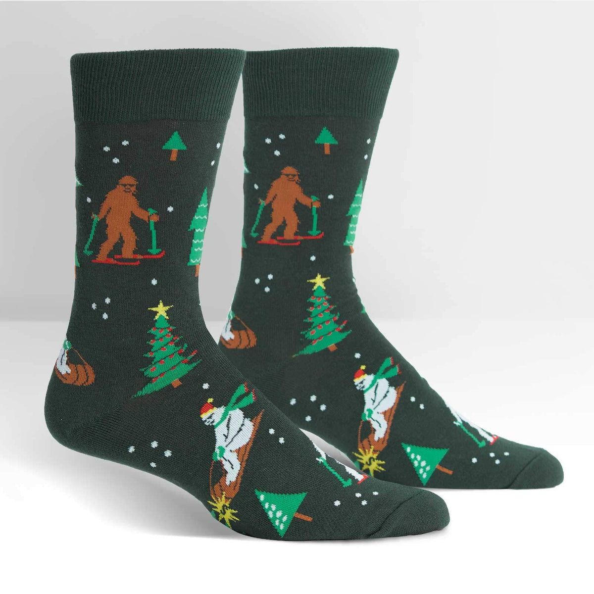 Sock It To Me Ready, Yeti, Go! men&#39;s crew sock featuring brown Sasquatch and white Yeti on skis. Socks on display feet. 