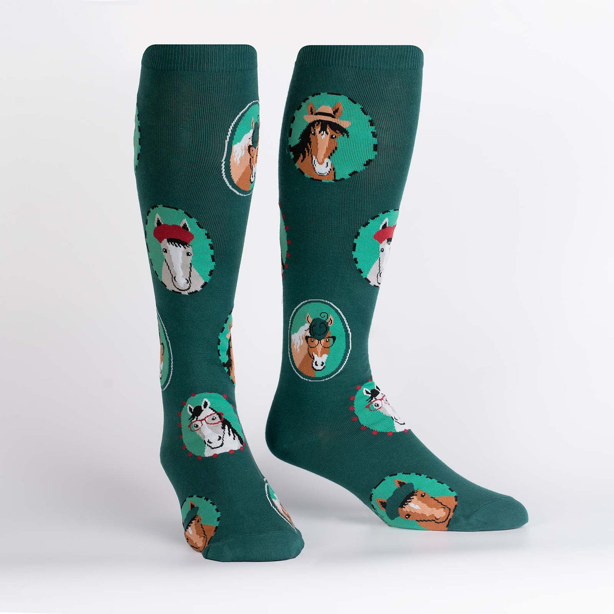 Sock It To Me Horsing Around extra-stretchy women&#39;s and men&#39;s knee high socks featuring teal socks with pictures of horses wearing hats and/or glasses. Socks shown on display feet. 