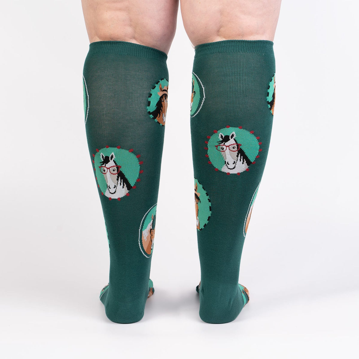 Sock It To Me Horsing Around extra-stretchy women&#39;s and men&#39;s knee high socks featuring teal socks with pictures of horses wearing hats and/or glasses. Socks shown on model from back
