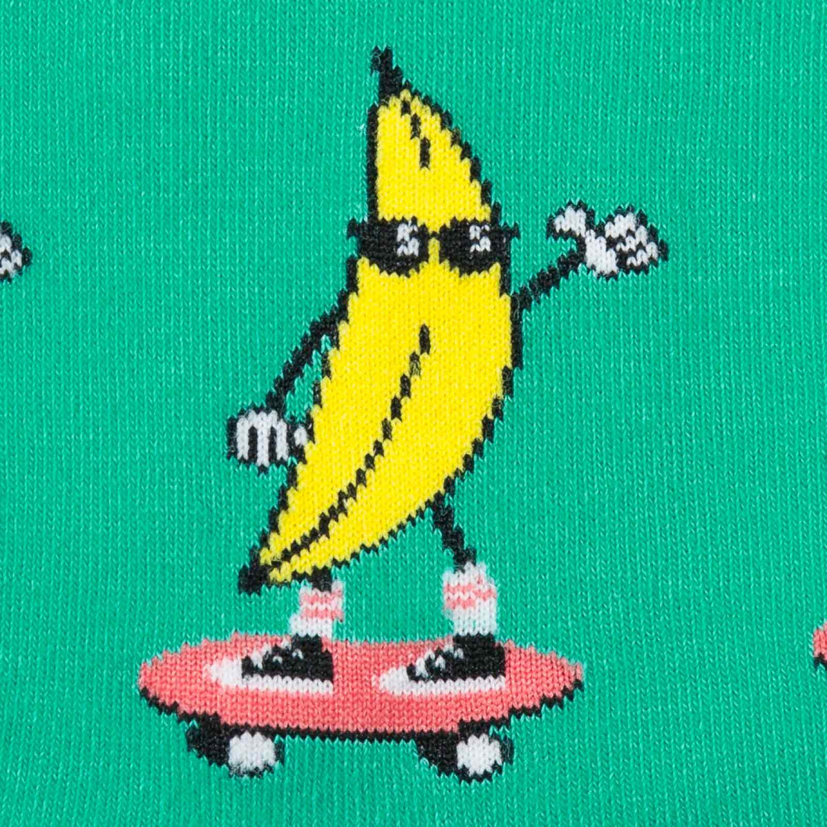 Detail of Sock It To Me Peeling Out men&#39;s crew sock featuring green sock with bananas in sunglasses on skateboards all over.