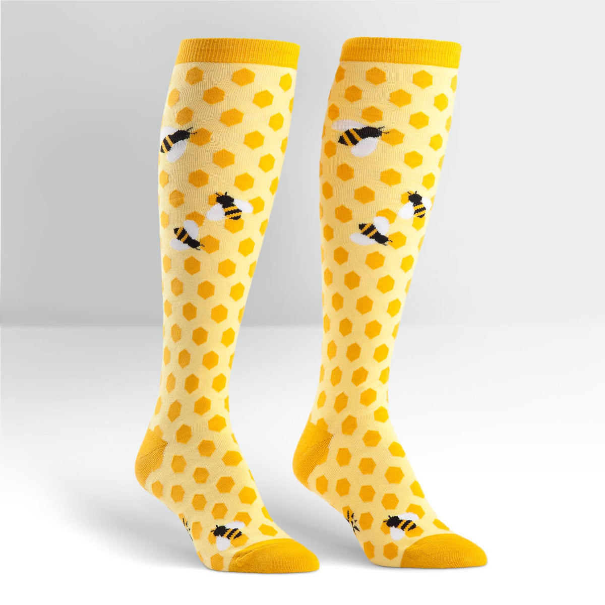 Sock It To Me women&#39;s knee high sock Bees KneesSock It To Me women&#39;s yellow knee high sock Bees Knees featuring honeycomb and bees all over on display feet
