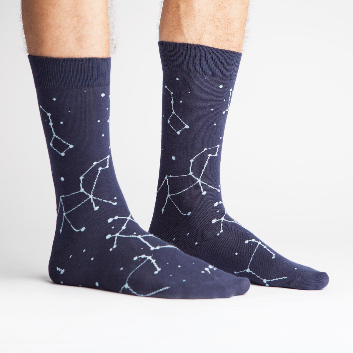 Sock It To Me Constellation (GLOWS IN THE DARK!) men&#39;s navy blue sock featuring constellations all over worn by model from side